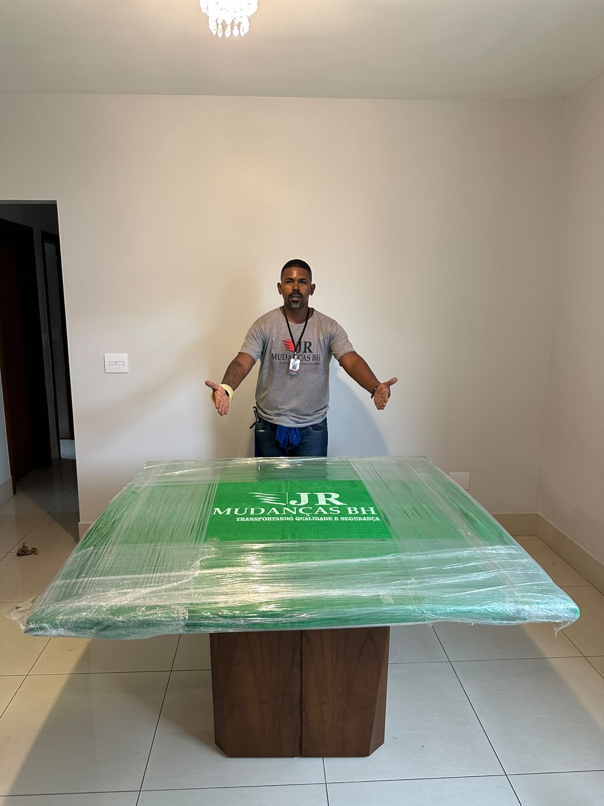 Profissional da JR ao lado de mesa embalada com proteção